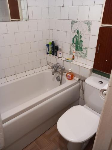 W łazience znajduje się biała toaleta, wanna i umywalka. w obiekcie Sunflower w Jurmale