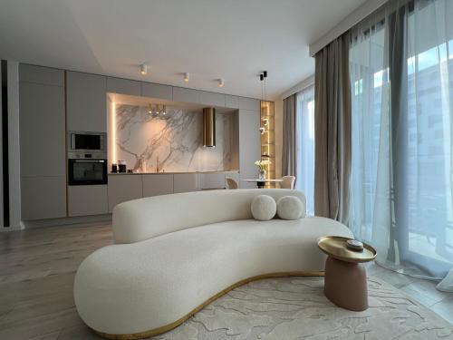 uma sala de estar com um grande sofá branco num quarto em Harmony property WIN HERASTRAU em Bucareste