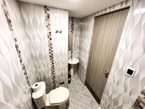 a bathroom with a toilet and a sink at Hotel y Restaurante Oasis CTG in Cartagena de Indias