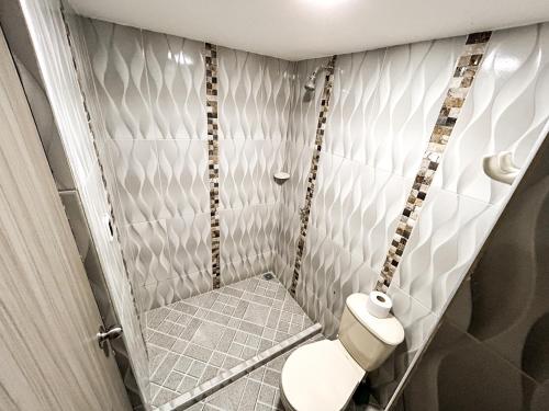 a small bathroom with a toilet in a room at Hotel y Restaurante Oasis CTG in Cartagena de Indias