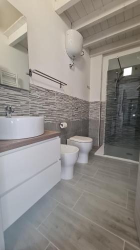 a bathroom with a sink and a toilet and a shower at Via Contu in Iglesias