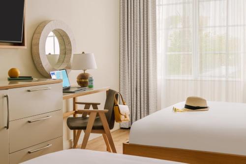 a bedroom with a bed and a desk with a hat on it at Sonder The Abbey in Miami Beach