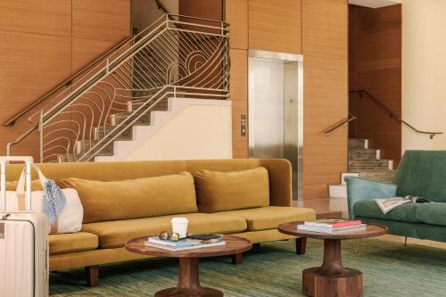 a living room with a couch and a staircase at Sonder The Abbey in Miami Beach