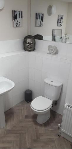a white bathroom with a toilet and a sink at Spacious Modern Apartment in Glasgow