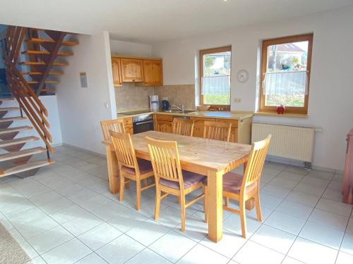 a kitchen with a wooden dining table and chairs at Ferienhäuser am Vogelpark - Boddenhaus Tizi in Marlow