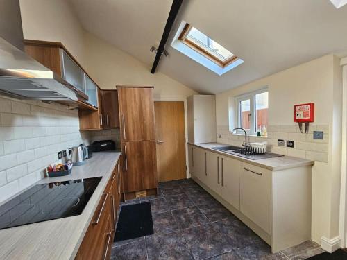 a kitchen with wooden cabinets and a skylight at Stratford Centre, Ground Level, Parking nearby in Stratford-upon-Avon