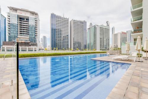 a swimming pool in the middle of a city with tall buildings at GlobalStay Reva & Vera Residences Business Bay Apartments in Dubai