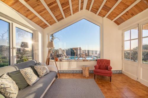 a living room with a couch and a red chair at CASAVADIA melides in Melides
