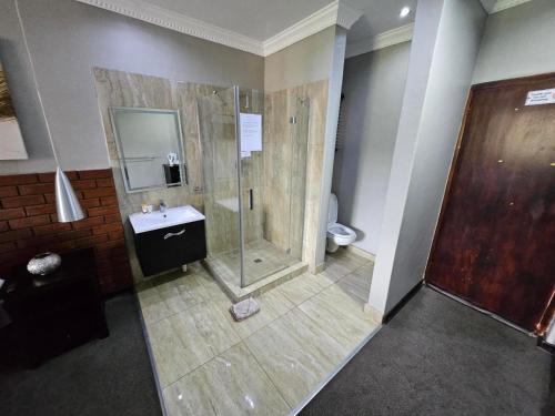 a bathroom with a shower and a sink at Pietersburg Club in Polokwane