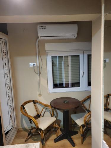 a room with a table and chairs and a air conditioner at Hostel Day Off in Aleksinac