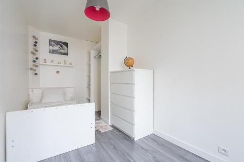 um quarto branco com um armário branco e um candeeiro vermelho em Loft spacieux à 10 minutes Champs-Élysées em Levallois-Perret