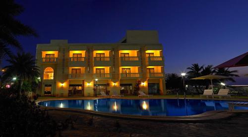 a building with a pool in front of it at night at MGM Vailankanni in Velankanni