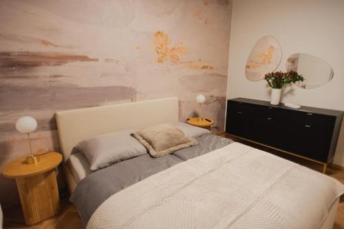 a bedroom with a bed and a painting on the wall at Gliwice Dickensa 36A Condo in Gliwice