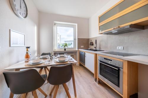 a kitchen with a table and chairs and a clock at Cityapartment Wagner mit Netlix in Bielefeld