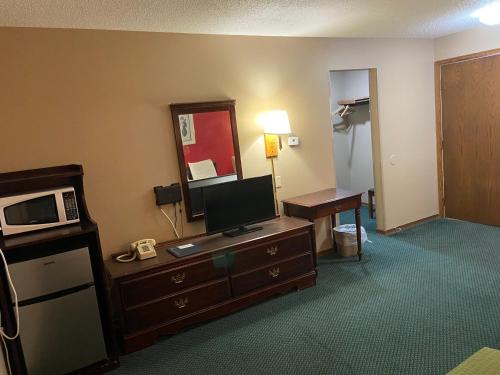 a hotel room with a television and a desk with a microwave at Colonial Inn in Dyersville