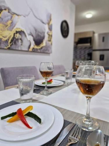 a table with a plate of food and glasses of wine at Depto. con club de Playa in Acapulco