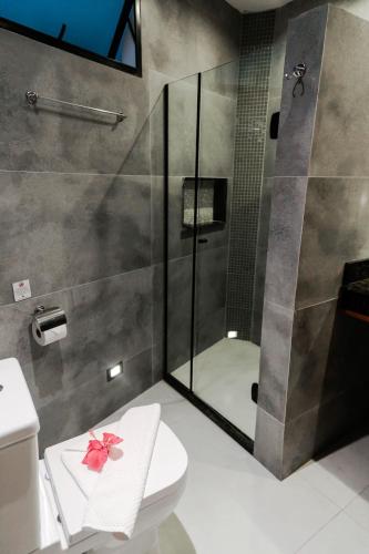 a bathroom with a shower and a toilet with a bow on it at Pousada da Torre in Morro de São Paulo