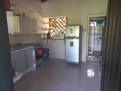 a kitchen with a refrigerator and a sink in it at casa de campo los gnomos, Venecia in Venecia
