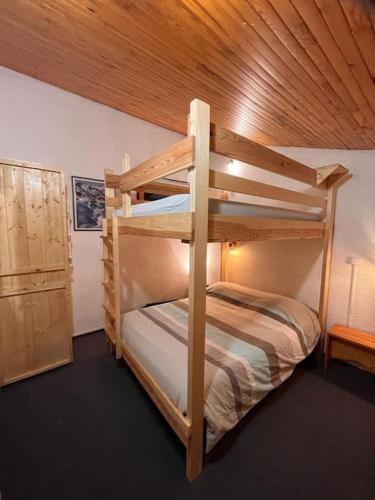 Cette chambre comprend 2 lits superposés et un plafond en bois. dans l'établissement Duplex plein sud_skis aux pieds_Plagne villages, à La Plagne Tarentaise
