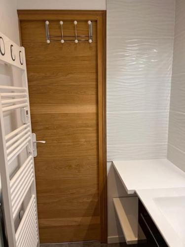 - une porte en bois dans la cuisine équipée d'un réfrigérateur dans l'établissement Duplex plein sud_skis aux pieds_Plagne villages, à La Plagne Tarentaise
