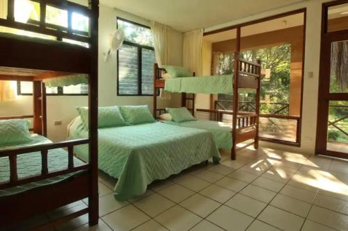 a bedroom with two bunk beds and a balcony at Luxurious entire country house in Rio Dulce, Guatemala in Rio Dulce