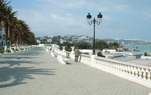 a man walking down a street next to a bridge at Victoria in La Marsa