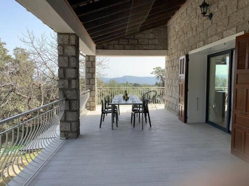 un patio avec une table et des chaises sur un balcon dans l'établissement Caminu di porto vecchio***. (Piscine chauffée ), à Porto-Vecchio