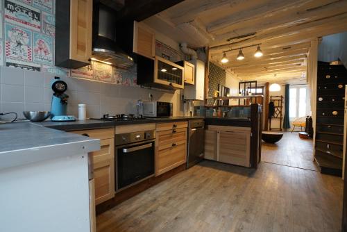 une cuisine avec parquet et une grande cuisine avec cuisinière dans l'établissement Maison cosy au bord de Loire - Vue Cathédrale, à Orléans