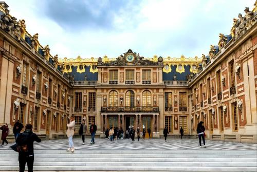 un gran edificio con gente parada frente a él en Charme et bien-être à 10 minutes du Château de Versailles, en Le Chesnay