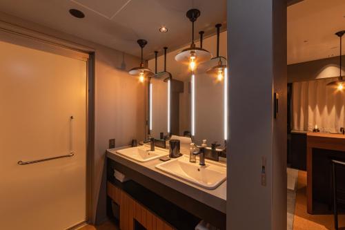 a bathroom with two sinks and a large mirror at Hotel Keihan Namba Grande in Osaka