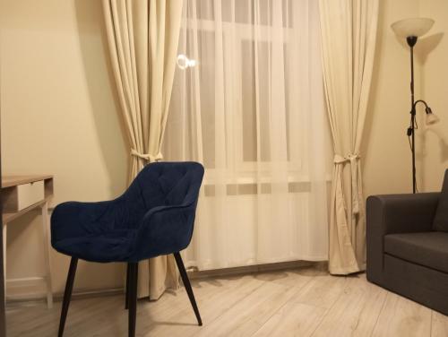 a living room with a blue chair and a couch at Jaaniku apartment. in Ahtme