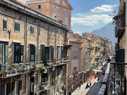 uma rua da cidade com edifícios e uma torre do relógio em Heritage Collection Palermo B&B em Palermo