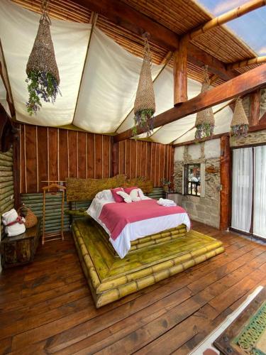 1 dormitorio con 1 cama en una habitación de madera en Cabaña Esmeralda - Seilan Alojamiento Rural en Paipa