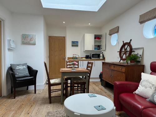 a living room with a red couch and a table at The Pilot Boat Inn, Isle of Wight in Bembridge