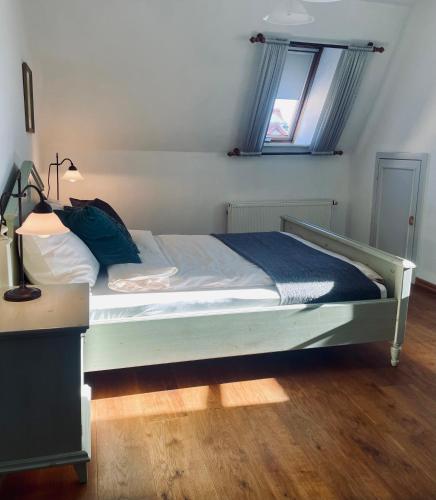 a bedroom with a white bed with a blue blanket at Hotel zur Schlossmühle in Borna
