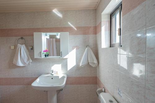 y baño con lavabo y espejo. en Ocean Breeze Apartment, en Kypseli