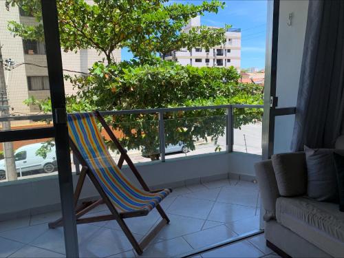 a rocking chair on a balcony with a view of a street at Apartamento no Guarujá para 8 pessoas in Guarujá