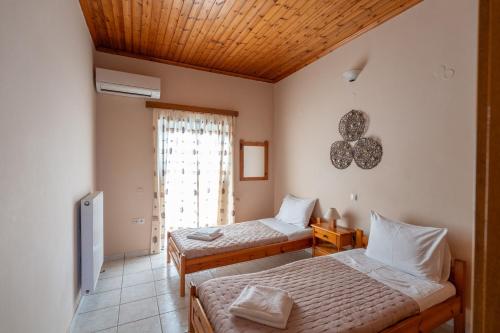 1 dormitorio con 2 camas y ventana en Ocean Breeze Apartment, en Kypseli