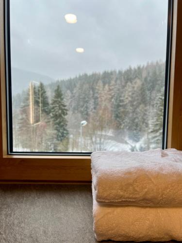 a towel sitting next to a window with a view at Golden Ridge Apartments in Špindlerův Mlýn