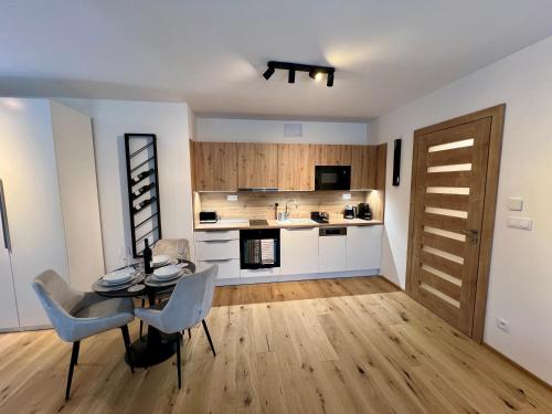a kitchen with a table and chairs in a room at Golden Ridge Apartments in Špindlerův Mlýn