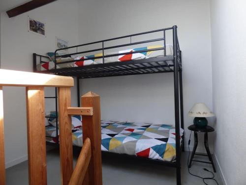 1 Schlafzimmer mit 2 Etagenbetten und einer Lampe in der Unterkunft T2 DUPLEX - VUE MER - 150 m DE LA PLAGE in Ploemeur