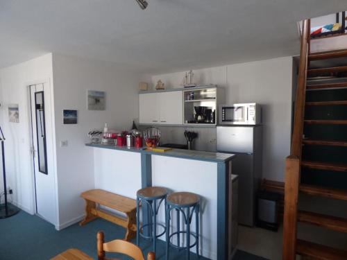 - une cuisine avec un comptoir et quelques tabourets dans l'établissement T2 DUPLEX - VUE MER - 150 m DE LA PLAGE, à Ploemeur