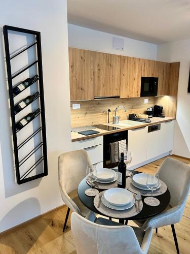 a dining room with a table and chairs and a kitchen at Golden Ridge Apartments in Špindlerův Mlýn