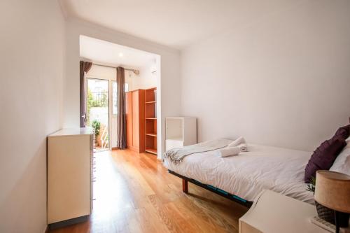 a small bedroom with a bed and a window at En2val1028 - Eixample Esquerra with terrace in Barcelona