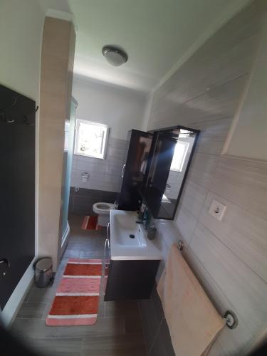 a bathroom with a sink and a mirror and a toilet at Franceska in Korčula