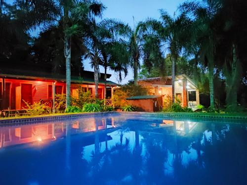 a swimming pool in front of a house at night at Posada 21 Oranges in Puerto Iguazú