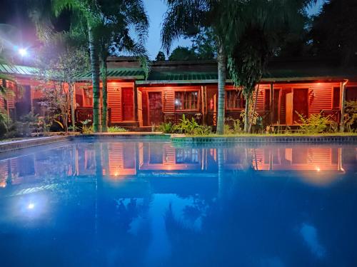 a swimming pool in front of a house at night at Posada 21 Oranges in Puerto Iguazú