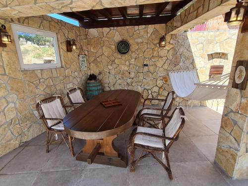 drewniany stół i krzesła w pokoju z kamienną ścianą w obiekcie Bellavista Medulin Sea View w Medulinie