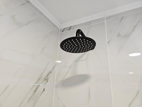 a shower with a black shower head in a bathroom at Impero Nafplio Hotel & Suites in Nafplio