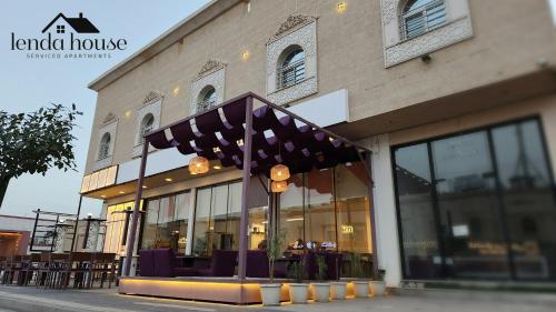 un restaurante con sillas moradas frente a un edificio en Lenda House en Medina